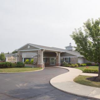 A welcoming entrance to a well-designed building surrounded by landscaped greenery.