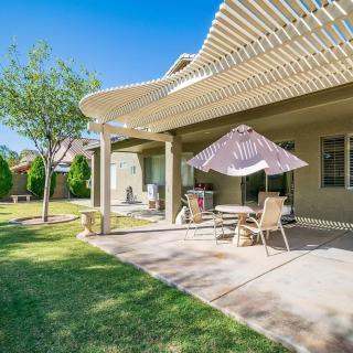 A sunny backyard patio with outdoor furniture and a pergola.