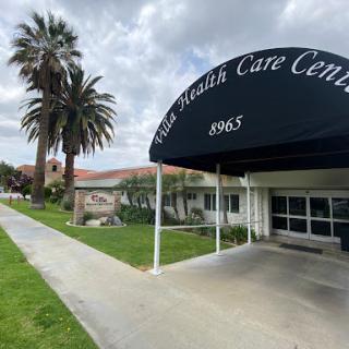 Exterior view of a health care center featuring palm trees and a welcoming entrance.