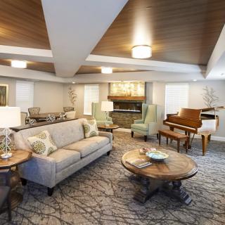 A well-furnished living room featuring a sofa, coffee table, and a grand piano.