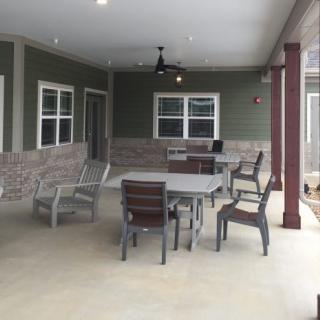 A covered patio area with outdoor furniture including a table and chairs.