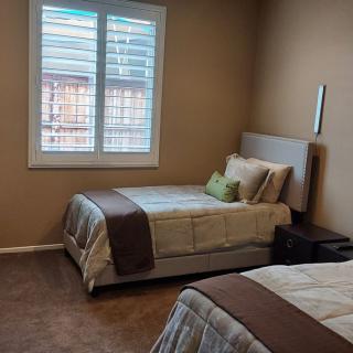 A cozy bedroom with two twin beds and a window with shutters.