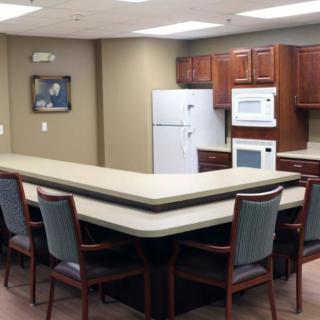 A modern kitchen and conference area with seating and appliances.