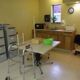 A functional room designed for rehabilitation, featuring a kitchenette and medical equipment.