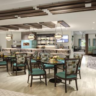 A modern restaurant interior featuring a well-designed dining area with stylish furniture and lighting.