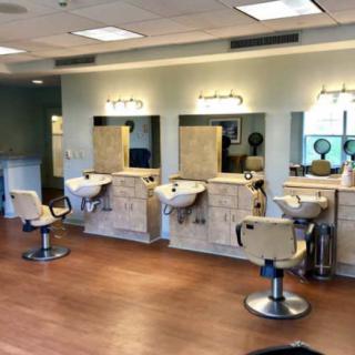 A modern hair salon interior with styling chairs, mirrors, and washing stations.