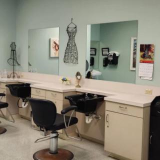 A stylish hair salon featuring mirrors, chairs, and sinks lined up against a wall.