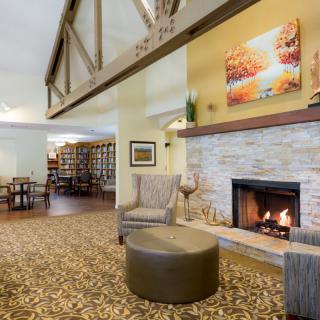 A cozy living room with a fireplace, comfortable seating, and warm decor.