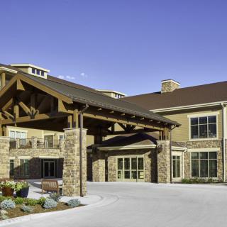 A modern building entrance with stone and wood architectural elements.