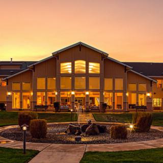 A scenic view of a well-lit building at sunset.