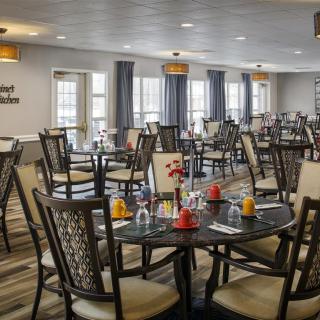 An empty dining room with neatly arranged tables and chairs, ready for guests.