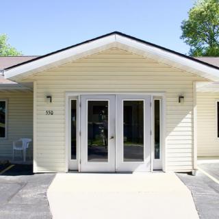 A small building with a front entrance featuring double glass doors.