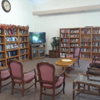 A cozy library corner with bookshelves, a TV, and seating.