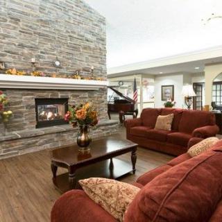 A cozy living room with a stone fireplace, comfortable couches, and elegant decor.