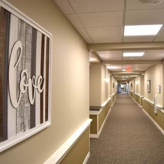 A long hallway with a framed artwork displaying the word 'love' on the wall.