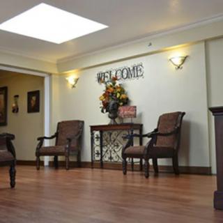 A welcoming waiting room featuring comfortable chairs and a decorative table beneath a 'Welcome' sign.