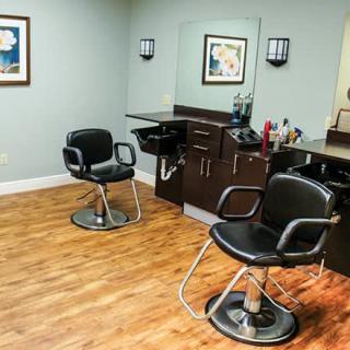 A cozy hair salon with stylish chairs and mirrors on a wooden floor.