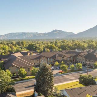A scenic view of a residential area with mountains in the background on a sunny day.