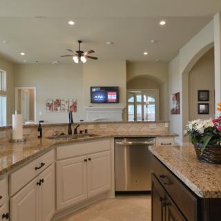 A modern kitchen featuring granite countertops and stainless steel appliances in an open layout.