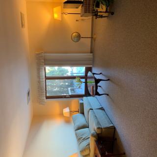 A cozy living room with a sofa, lamp, and large window.