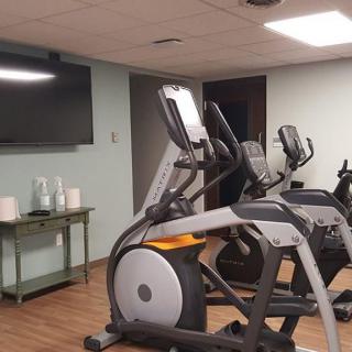 A fitness room featuring elliptical machines and a television.