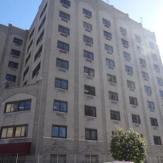 A multi-story urban building with modern architectural design and a clear blue sky.