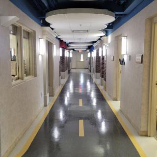 A well-lit, modern hallway with doors on either side.