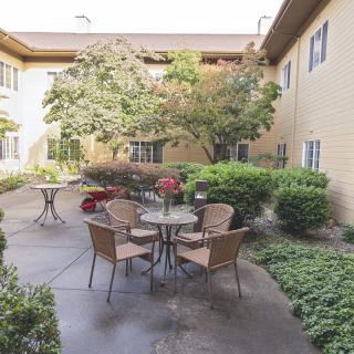 A tranquil courtyard with seating surrounded by lush greenery.
