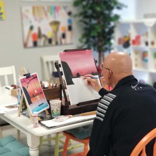An artist working on a painting in an art studio.