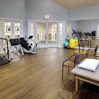 A spacious fitness area equipped with various exercise machines and physical therapy tools.