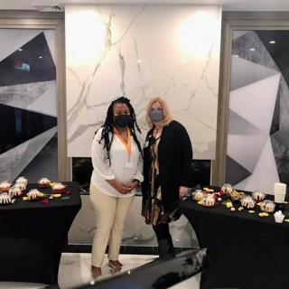 Two women posing together at an elegantly decorated event.