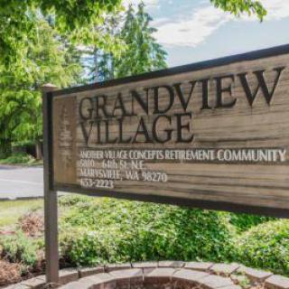 Sign for Grandview Village retirement community surrounded by greenery.
