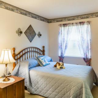 A cozy bedroom with a neatly made bed and soft lighting.