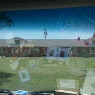 A view of a house and lawn from inside a vehicle.