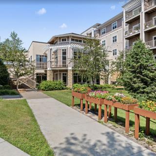A modern apartment building with landscaped gardens and a walkway.