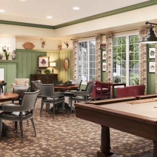 A cozy game room with a pool table, comfortable seating, and large windows providing natural light.