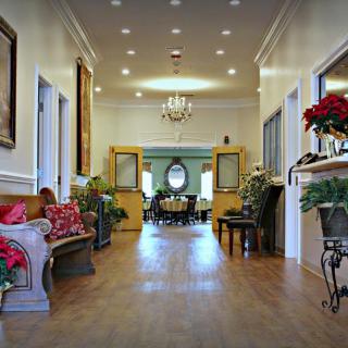 A well-decorated hallway with elegant furnishings and a chandelier.