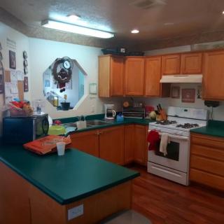 A cozy kitchen with wooden cabinets and green countertops.