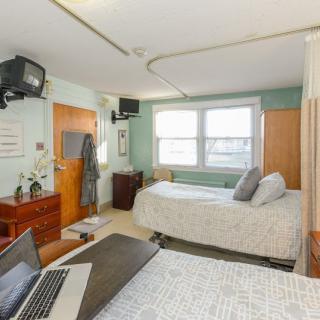 A hospital room with two beds and medical equipment.