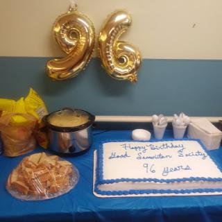 A festive setup for a 96th birthday celebration with cake and decorations.