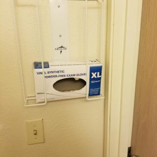 A wall-mounted dispenser holding XL gloves for hygienic use.