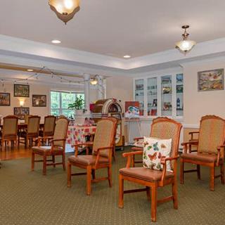 A cozy interior space featuring wooden chairs and a dining area.