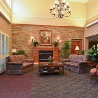 A cozy lobby featuring comfortable sofas, a coffee table, and a fireplace with elegant decor.