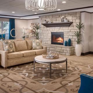 A cozy living room with a fireplace, beige sofa, and a stylish coffee table.