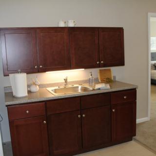 A compact kitchen setup with wooden cabinets and a sink.