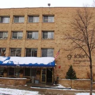 A brick building with a snow-covered entrance and trees in winter.