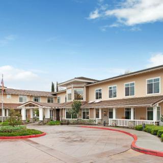 A two-story residential building with a circular driveway and landscaped entrance.