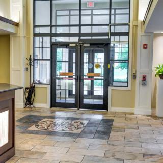 A view of a lobby entrance with decorative tiles and a reception area.