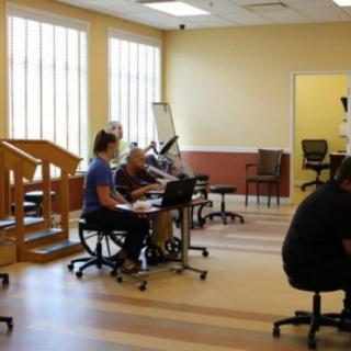 A physical therapy clinic with patients and therapists during a session.