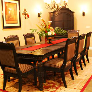 A traditional dining room with a large table, elegant chairs, and a chandelier.